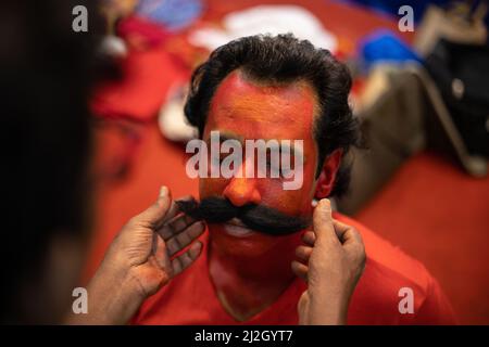 L'artista di makeover che collega i baffi finti al volto dell'uomo dovrebbe giocare il ruolo di Virabhadra per la performance di danza folk annuale a Goa Foto Stock