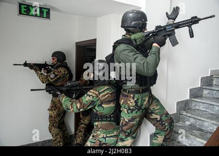 Tre membri dell'unità di intervento speciale del Kosovo si sono divisi in diverse direzioni per liberare un edificio durante un esercizio di formazione bilaterale con il gruppo delle forze speciali 10th, 18 marzo 2022, a Pristina, Kosovo. L’esercizio rafforza le relazioni, aumenta l’interoperabilità e aumenta la capacità della nostra nazione partner di garantire la sicurezza nella regione balcanica. (STATI UNITI Foto dell'esercito di Sgt. Stanford Toran) Foto Stock