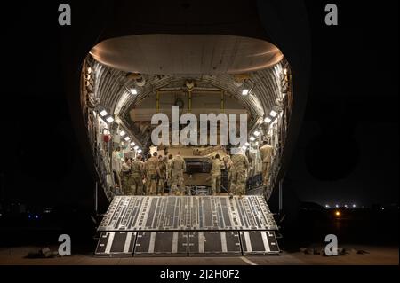 Soldati e Airmen statunitensi con la squadra di combattimento di Cavalry Brigade del 116th e la 386th Air Expeditionary Wing caricano un carro armato M1A2 Abrams su un aereo C-17 Globemaster III alla base aerea Ali al Salem, Kuwait, 16 marzo 2022. Ciò ha dimostrato le capacità di implementazione rapida di U.S. Air Force and Army in tutta l'area di responsabilità del comando centrale degli Stati Uniti. (STATI UNITI Air Force foto di Senior Airman Natalie Filzen) Foto Stock