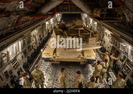 Soldati e Airmen statunitensi con la squadra di combattimento di Cavalry Brigade del 116th e la 386th Air Expeditionary Wing caricano un carro armato M1A2 Abrams su un aereo C-17 Globemaster III alla base aerea Ali al Salem, Kuwait, 16 marzo 2022. Ciò ha dimostrato le capacità di implementazione rapida di U.S. Air Force and Army in tutta l'area di responsabilità del comando centrale degli Stati Uniti. (STATI UNITI Air Force foto di Senior Airman Natalie Filzen) Foto Stock