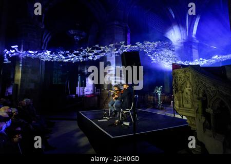 Edimburgo, Scozia. Ven 1 Aprile 2022. Piper Brìghde Chaimbeul e Aidan o'Rourke suonano dal vivo nella cattedrale di St Giles come parte del festival Burns & Beyond. Il concerto si è svolto sotto l’installazione d’arte di Michael Pendry ‘Les Colombes (i Dogi)’, una colonna tortuosa di oltre 2.500 colombe di carta origami che volano per tutta la lunghezza della Cattedrale. Foto Stock