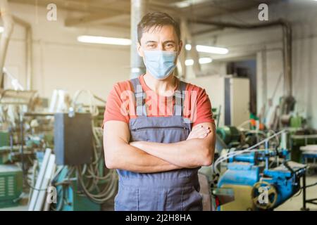 Carpentiere in maschera medica in piedi in Falegnameria Foto Stock