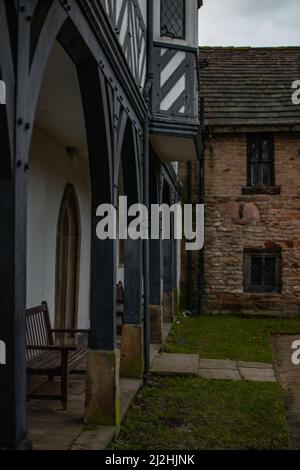 Archi in legno che conducono in un edificio in pietra costruito a mano a Smithills Hall, Bolton, Regno Unito. Foto Stock