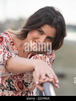 Ritratto di una giovane bella donna in abbigliamento casual estate sorridente felice alla spiaggia. Foto Stock