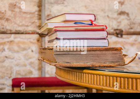 Uno sopra l'altro, un mucchio di vecchi libri dilapidati accatastati. Foto Stock