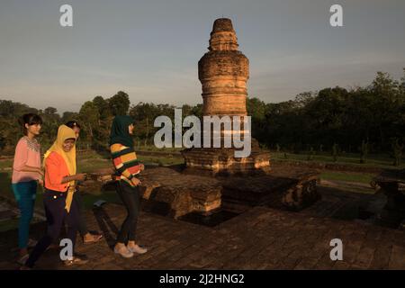 Giovani donne che hanno un tempo di svago al tempio di Muara Takus a Kampar, Riau, Indonesia. Il tempio si trova vicino al fiume Kampar che il suo estuario era un importante porto commerciale dell'antico regno malese che è stato registrato da Chau Ju-kua (Zhao Rugua), un commissario cinese del 13th secolo per il commercio internazionale che ha lavorato per la dinastia Song. L'antico regno malese (costituito dalle attuali province di Sumatra occidentale, Riau e Jambi) fu conquistato e controllato dalla Srivijaya dal 7th al 11th secoli. 'il regno di Kien-pi (Kampar, antico regno malese) si trova proprio alla foce della strada... Foto Stock