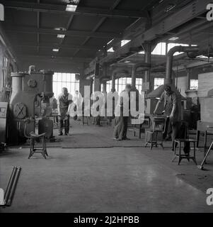 1950s, storico, negozio di un'officina di forgiatura, lavoratori maschi che formano e modellano metalli utilizzando le attrezzature del giorno per martellare, pressare o rotolare il metallo, Abbey Works Steel Complex, Port Talbot, Galles, Regno Unito. Foto Stock