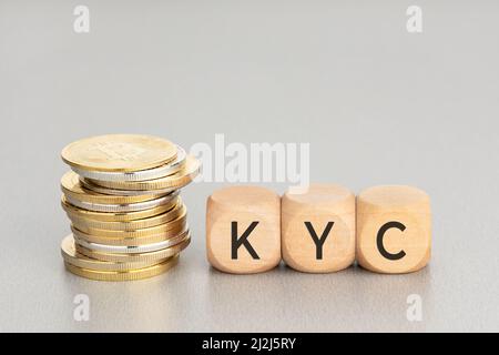 Concetto di criptovaluta KYC. Monete cripto impilate e blocchi di legno con testo. Spazio di copia Foto Stock