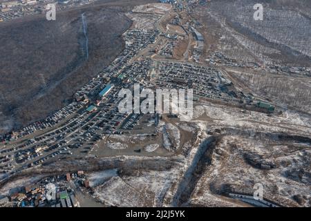 File di auto in piedi al mercato auto girato dall'alto. Vendita di auto usate portate dal Giappone. Foto Stock