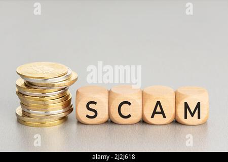 Concetto di truffa della criptovaluta. Monete cripto impilate e blocchi di legno con testo. Spazio di copia Foto Stock