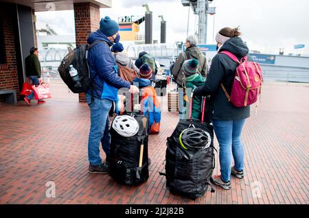 Norddeich, Germania. 02nd Apr 2022. Una famiglia attende con i bagagli al terminal dei traghetti nel porto per l'attraversamento dell'isola di Norderney. Nel 04.04.2022 iniziano le vacanze pasquali in bassa Sassonia, Brema e Schleswig-Holstein, già in questo fine settimana molti turisti sono attesi sulla costa. Credit: Hauke-Christian Dittrich/dpa/Alamy Live News Foto Stock