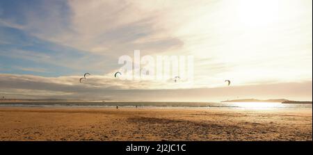 I kite surfers scivolano sulle onde dell'oceano Atlantico. Concetto di svago attivo. Paesaggio panoramico Foto Stock