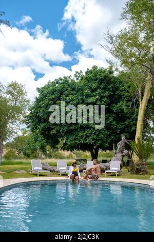 Coppia uomini e donne in piscina in un safari di lusso, Sud Africa l, safari Lodge di lusso nel bush di una riserva di gioco Foto Stock