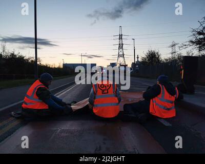 Foto di handout pubblicata da Just Stop Oil dei manifestanti che hanno bloccato una strada vicino al Titan Truck Park a Grays, Essex, dove affermano di aver costruito una rete segreta sotterranea di tunnel presso i terminal petroliferi Navigator e Grays. I manifestanti chiedono al governo britannico di bloccare nuovi progetti nel settore del petrolio e del gas. Data di emissione: Sabato 2 aprile 2022. Foto Stock