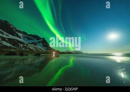 Spiaggia di Skagsanden illuminata dal chiaro di luna durante l'aurora boreale, Flakstad, Isole Lofoten, Norvegia Foto Stock