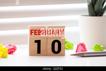 Calendario a forma di cubo per febbraio 10 su superficie di legno con spazio vuoto per il testo Foto Stock