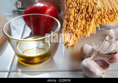 Macro fotografia, spaghetti crudi, crudi, crudi, con ingredienti su un tavolo, pronti per cucinare. Foto Stock