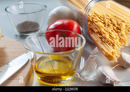 Macro fotografia, spaghetti crudi, crudi, crudi, con ingredienti su un tavolo, pronti per cucinare. Foto Stock