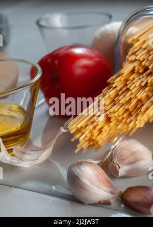 Macro fotografia, spaghetti crudi, crudi, crudi, con ingredienti su un tavolo, pronti per cucinare. Foto Stock