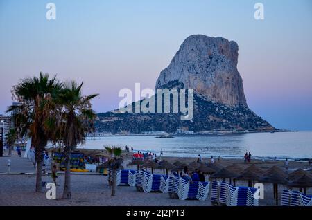 Vista sulla spiaggia di Calpe fino alla roccia Penyal d'Ifac nel Mar Mediterraneo alla luce del tramonto Foto Stock