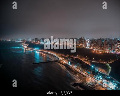 Una vista areale sulla costa pacifica del distretto di Miraflores a Lima, Perù di notte Foto Stock