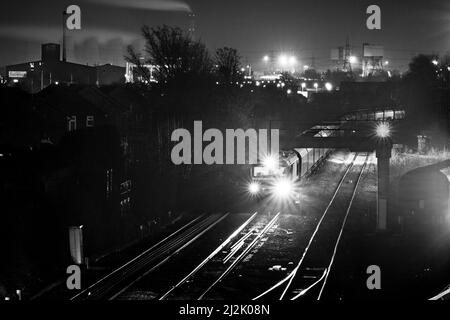 DB Schenker classe 66 locomotiva a Knottingley di notte con la centrale elettrica di Eggborough e Kellingley scontrarsi dietro Foto Stock