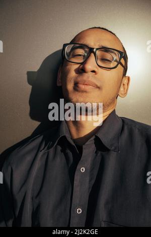 Ritratto arrabbiato uomo urlando in studio. Primo piano ragazzo afroamericano gridando su sfondo nero. Modello maschio espressione della faccia aggressiva. Uomo serio Foto Stock