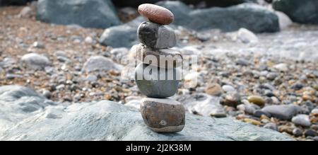 Pyramide de galets sur la plage Foto Stock