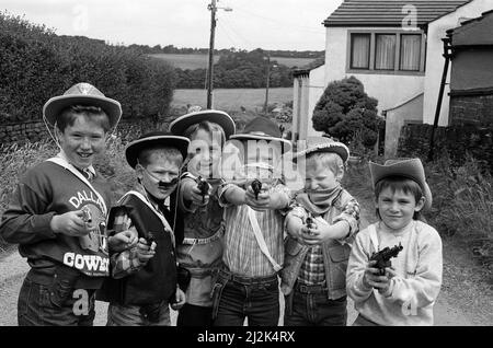 Esso¿ un bastone-up? Da un mazzo realistico osservare da Almondbury ad un Cowboys ed Indians Fun-Day per i beaver scouts. I sei minacciosi sono (da sinistra) Dale Sidebottom, Adam Shaw, Adam Schofield, Simon Blackmoor, Marcus Addy e Adam Lancaster. Erano tra i 150 cavatori di età compresa tra i sei e gli otto anni, provenienti dai tre distretti di Huddersfield Scout che hanno vissuto un tocco del selvaggio West a Whitley Beaumont, tra cui un percorso avventura, canti del fuoco e una cena da cowboy di fagioli e fagioli. 9th luglio 1988. Foto Stock