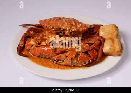 GRANCHIO DI CILI SINGAPORIANI con salsa in un piatto vista dall'alto su sfondo grigio Singapore food Foto Stock