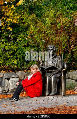 Ritratto dell'attrice Inger Nilsson che ha interpretato Pippi di Astrid Lindgren. Fotografato a Djurgården a Stoccolma. A destra la statua di Astrid Lindgren. Foto Stock