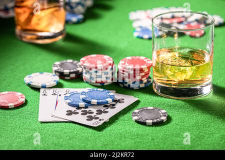 Tavolo da gioco del poker con carte, fiches e shiksy. Tavolo da poker con carte, fiches e un bicchiere di whiskey con ghiaccio. Foto Stock