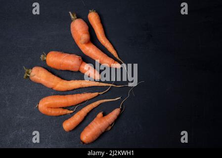 carota, arancio naturale brutto organico numerose carota su fondo nero isolato da vicino Foto Stock
