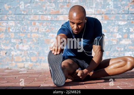 Uscire non è nemmeno un'opzione. Scatto di un giovane sportivo che pratica la sua routine di esercizio. Foto Stock