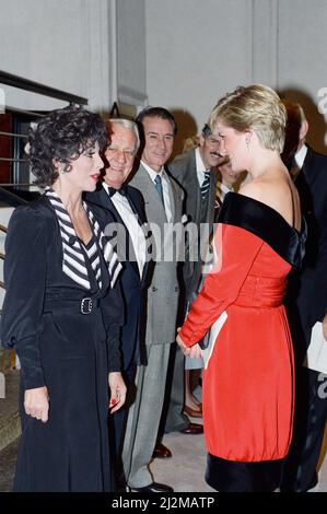 La principessa Diana con l'attrice Joan Collins dopo un'esecuzione benefica della commedia Private Lives all'Aldwych Theatre di Londra. La principessa indossa un nuovo abito da cocktail di seta rosso laccato con colletto e orlo di velluto nero di Victor Elderstein. Presenta una cintura larga e una scollatura a spalla. 24th settembre 1990. Foto Stock