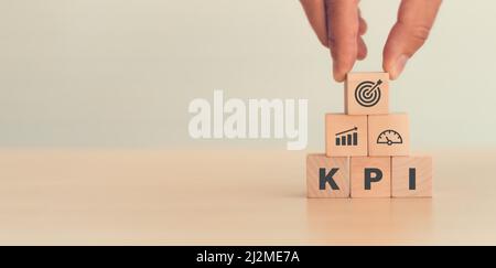 KPI, Key Performance Indicator (indicatore prestazioni chiave). Businessman ha un cubo con l'icona KPI; obiettivi aziendali, risultati delle prestazioni e indicatori . Per la pianificazione aziendale e m Foto Stock