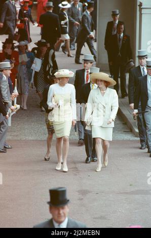 HRH la Principessa del Galles, la Principessa Diana (a sinistra) e la Duchessa di York (a destra) si godono la giornata mentre camminano a parlare l'un l'altro all'evento Royal Ascot del 1991 giugno. La principessa Diana indossa un abito di seta bianco e limone progettato da Catherine Walker. E un cappello di sposa pieno di rosa. Progettista non noto. Foto scattata il 19th giugno 1991 Foto Stock