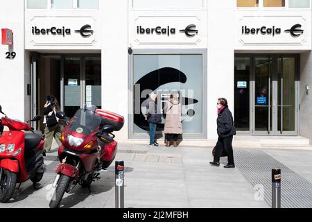 I clienti stanno ritirando denaro da un bancomat presso la società spagnola di servizi bancari finanziari Ibercaja in Spagna. Foto Stock