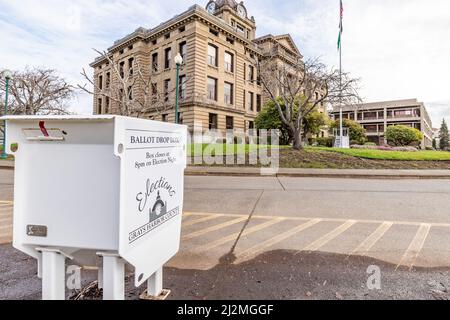 Montesano, WA - USA 03-25-2022: Guida in su voto casella con Grays Harbour Courthouse in background Foto Stock