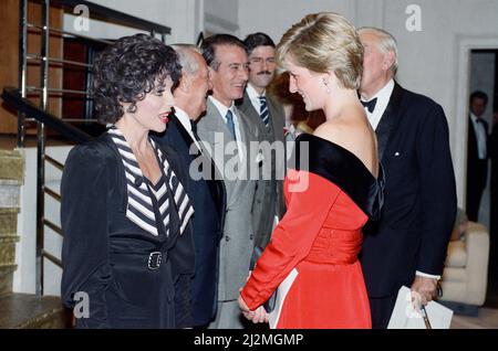 La principessa Diana con l'attrice Joan Collins dopo un'esecuzione benefica della commedia Private Lives all'Aldwych Theatre di Londra. La principessa indossa un nuovo abito da cocktail di seta rosso laccato con colletto e orlo di velluto nero di Victor Elderstein. Presenta una cintura larga e una scollatura a spalla. 24th settembre 1990. Foto Stock