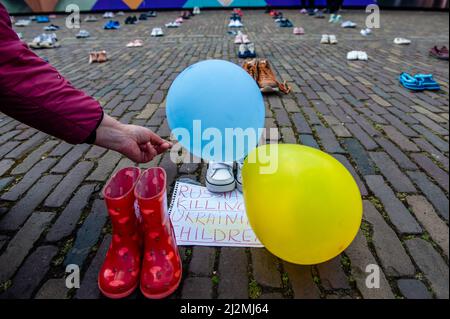 L'Aia, Paesi Bassi. 02nd Apr 2022. Durante la dimostrazione, un manifestante ha visto posizionare un palloncino giallo e blu accanto alle scarpe dei bambini. Di fronte alla Camera dei rappresentanti dei Paesi Bassi è stata posta un'installazione artistica Ucraina per richiamare l'attenzione delle autorità olandesi e della popolazione sulle uccisioni di civili e in particolare di bambini durante la guerra in Ucraina. (Foto di Ana Fernandez/SOPA Images/Sipa USA) Credit: Sipa USA/Alamy Live News Foto Stock