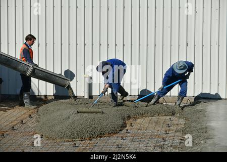 costruttori sparse cemento appena versato per una lastra concreta Foto Stock