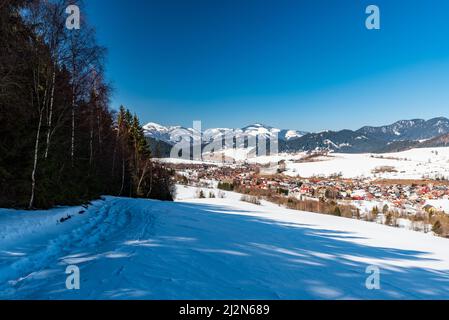 Villaggio di Liptovska Luzna con colline di Nizke Tatry e VelkaFatra montagne intorno in Slovacchia durante la bella giornata invernale Foto Stock