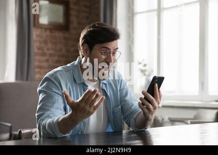 L'utente dello smartphone è entusiasta e lo schermo è sorpreso Foto Stock