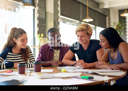 Prepararsi ad affrontare il test. Foto di un gruppo di giovani amici che hanno una sessione di studio in un bar. Foto Stock