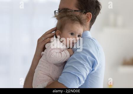 Buon papà giovane che tiene il bambino innocente nelle braccia Foto Stock