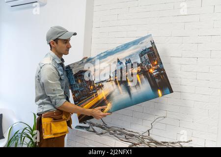 il padrone del riparatore tiene una tela della foto Foto Stock