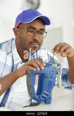 l'uomo sta cambiando una lama di taglio Foto Stock