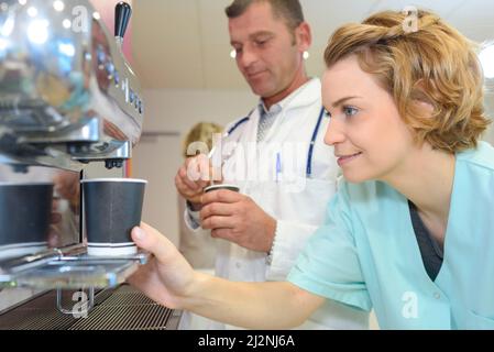 Medico con infermieri all'aperto godendo della pausa caffè Foto Stock