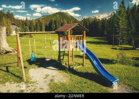 baby swing in natura, montagna in background. Foto Stock